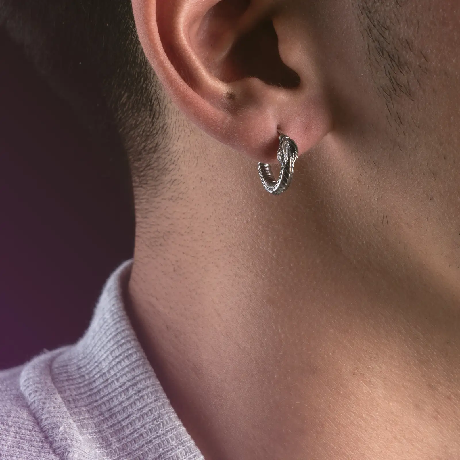 Silberner Creolen-Ohrring getragen am Ohr eines Mannes